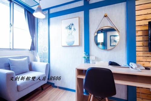 a room with a desk and a mirror and a chair at At Tainan Inn in Tainan