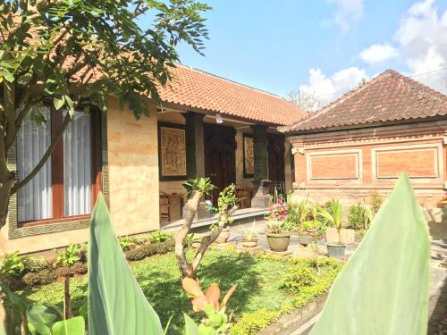 une maison avec un jardin en face dans l'établissement Hendra House, à Ubud