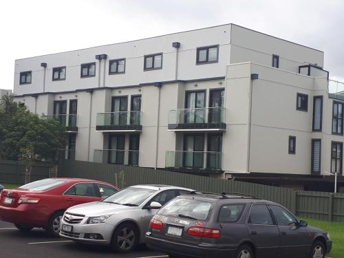 three cars parked in a parking lot in front of a building at Apartments in Phillip Island Towers - Block C in Cowes