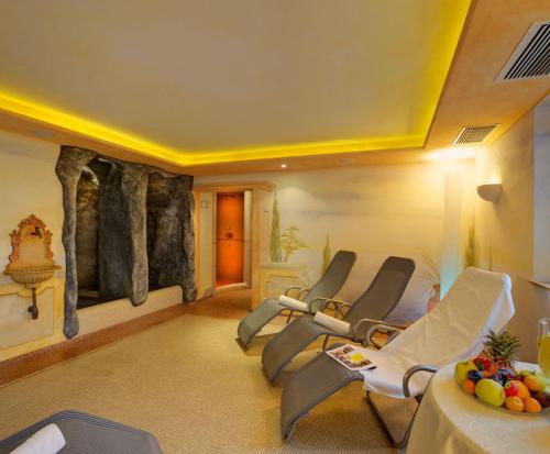 a fitness room with chairs and a rock wall at Hotel Laurin in Lagundo