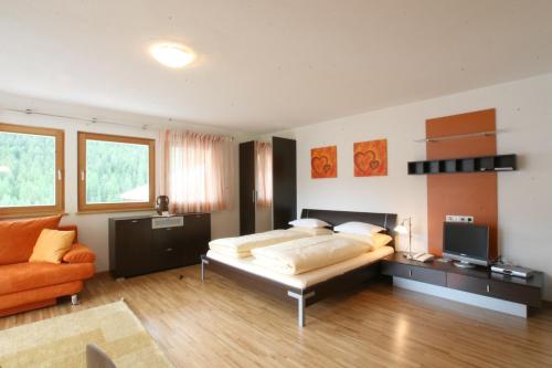 a large bedroom with a bed and a couch at Klimahaus Dep. La Fradora in San Cassiano