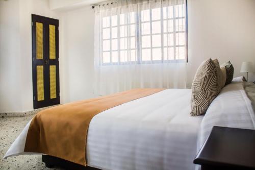 a bedroom with a large bed and a window at Múcara hotel in Veracruz