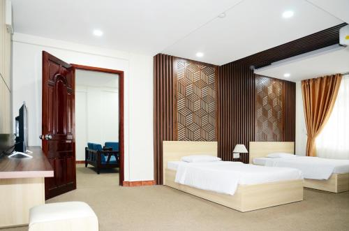 a bedroom with two beds and a television at Khách sạn Đồng Nai in Bien Hoa