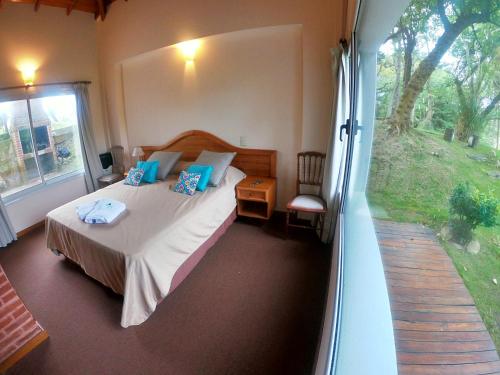 1 dormitorio con cama y ventana grande en Haras del Bosque en Mar de las Pampas