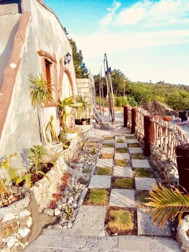 a stone walkway with plants on the side of a building at Kamp Aninipot in Siquijor