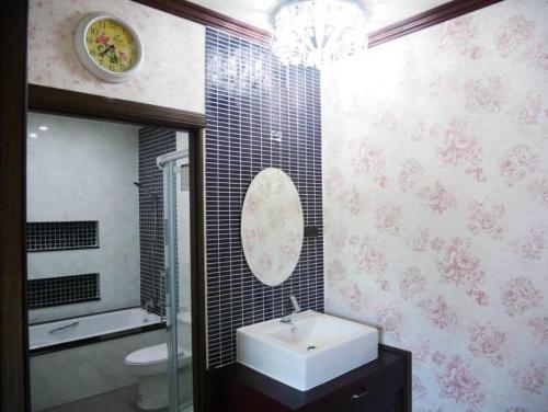 La salle de bains est pourvue d'un lavabo, de toilettes et d'un miroir. dans l'établissement Tinna Resort, à Ban Nong Mai Ngam
