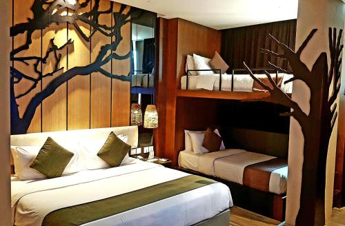 1 dormitorio con 2 camas y un mural de árboles en ESKA Hotel, en Batam Centre