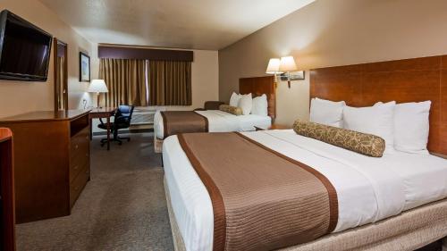 una camera d'albergo con 2 letti e una scrivania di Best Western Desert Oasis a Ehrenberg