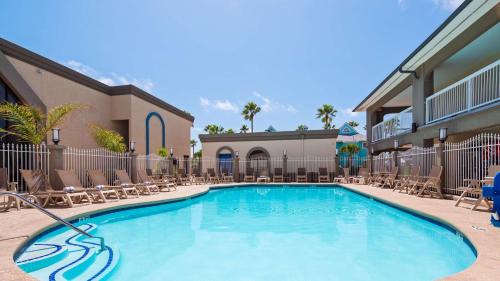 een zwembad met ligstoelen en stoelen bij Best Western Port Aransas in Port Aransas