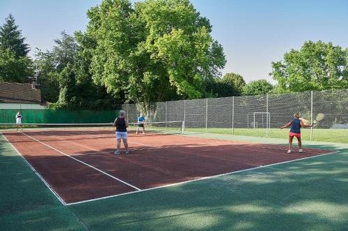 a group of people playing tennis on a tennis court at Village de Montmarsis in Gourdon-en-quercy