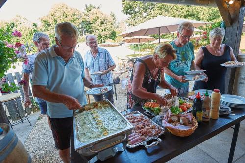 a group of people standing around a table with food at Village de Montmarsis in Gourdon-en-quercy