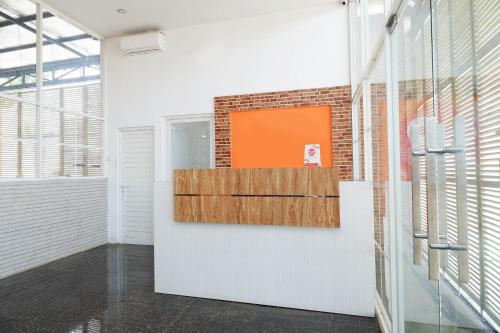 a hallway with a brick wall and an orange painting on the wall at Super OYO 1250 Unta Residence in Semarang