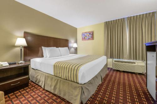 a hotel room with a large bed and a desk at Econo Lodge Inn & Suites Triadelphia - Wheeling in Triadelphia
