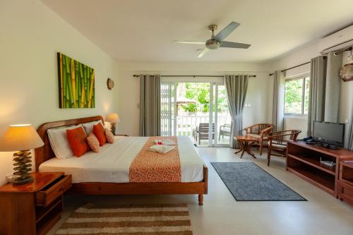 a bedroom with a bed and a television in a room at Le Tropique Villa in Grand'Anse Praslin