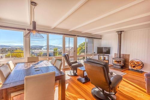 a dining room with a table and chairs and a fireplace at Mimosa Holiday House in St Helens