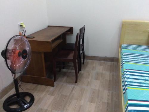 Pokój z biurkiem i wentylatorem obok stołu w obiekcie Ngũ Hành Sơn w mieście Da Nang