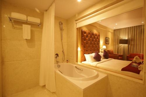 a bathroom with a bed and a bath tub in a room at The Chancery Hotel in Bengaluru