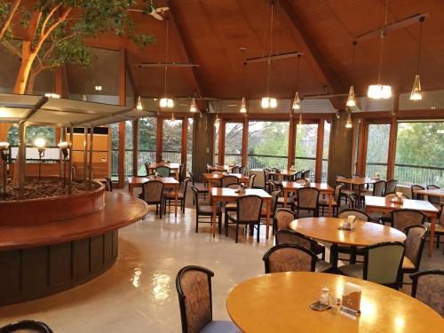 a restaurant with tables and chairs and windows at Hotel Heritage in Kumagaya