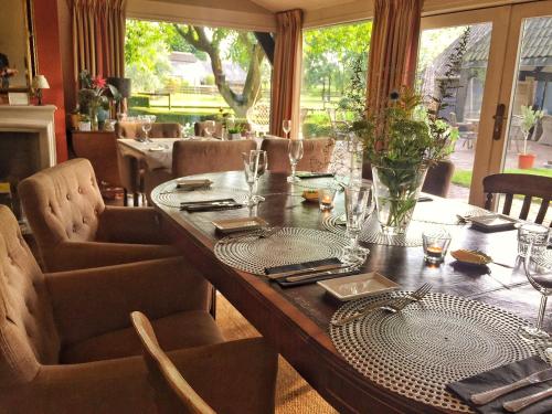mesa de madera con sillas y comedor con mesa en Landrop Bed & Breakfast, en Hoogeloon