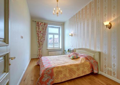 een slaapkamer met een bed en een raam bij Ilo Apartamentai in Vilnius