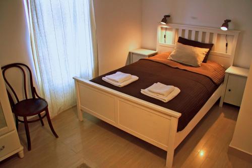 a bedroom with a bed with two towels on it at Mi a Kő vendégház in Köveskál