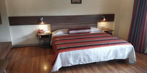 a hotel room with a bed and a desk at Nasiklub in Nashik