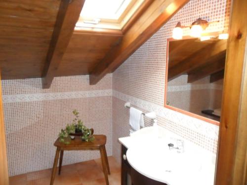 La salle de bains est pourvue d'un lavabo, d'un miroir et d'une table. dans l'établissement Apartamentos Rurales Los Villares, à Colunga