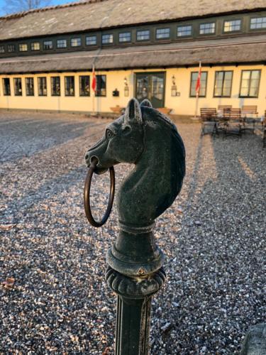 a statue of a horse with a pipe in its mouth at Munkebo Kro & Hotel in Munkebo