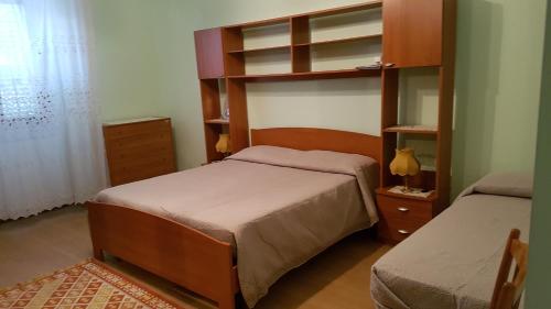 a bedroom with two beds and a book shelf at Casa Rosa in Montella