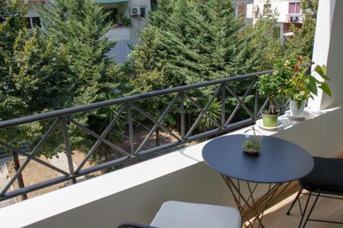 balcón con mesa, sillas y árboles en Roza's Studio Tirana Center en Tirana