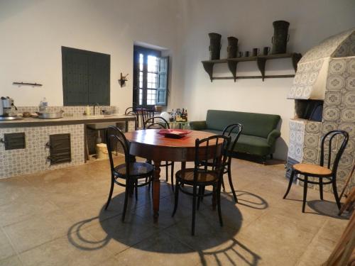 cocina y comedor con mesa y sillas en Masseria Acque Di Palermo, en Roccapalumba