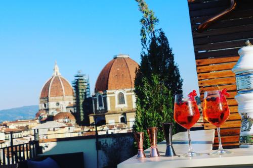 two wine glasses on a ledge with a view of a building at Hotel Machiavelli Palace in Florence