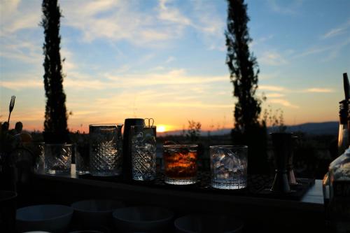 a group of glasses on a table with the sunset in the background at Hotel Machiavelli Palace in Florence