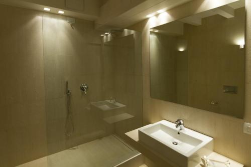 a bathroom with a sink and a shower and a mirror at La Casa Del Porto in Lovere