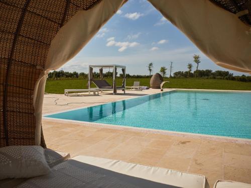 a view of a swimming pool from a tent at Masseria Elysium in Mesagne