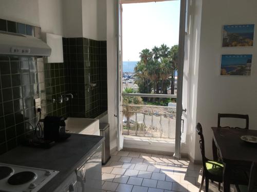 une cuisine avec une grande fenêtre donnant sur l'océan dans l'établissement Sun Beam Cannes, à Cannes
