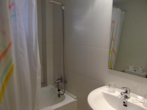 a bathroom with a sink and a shower with a mirror at Hotel Simeon in Tossa de Mar