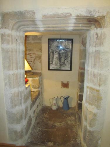 um quarto com uma parede de pedra com uma imagem na parede em Le Relais de la Tour em Figeac