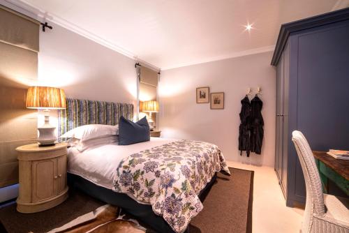 a bedroom with a bed and a table with a lamp at Ocean Breeze by The Oyster Collection in Kenton on Sea