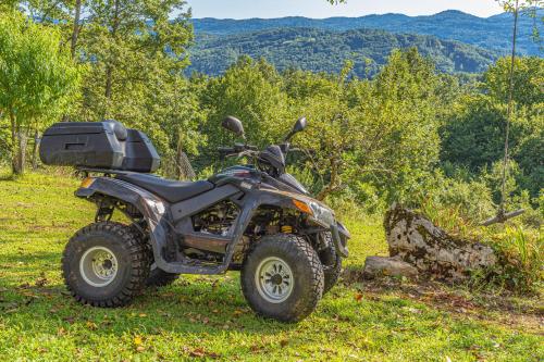 a four wheeler parked in a field of grass at Grey green and fun 4 YOU - 2 Cottages in Drganja Sela