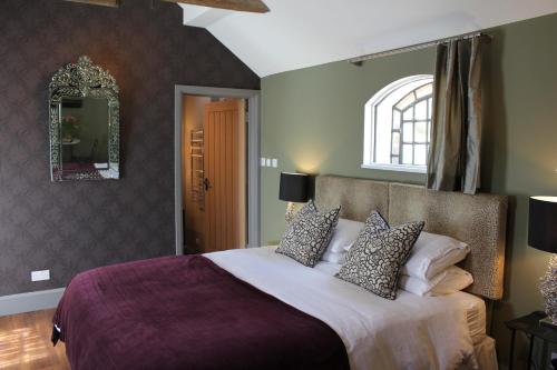 1 dormitorio con 1 cama grande y espejo en Hayeswood Lodge Luxury Accommodation, en Stanley