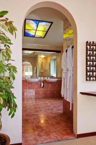 a bathroom with two sinks and a stained glass window at Hotel Mastbosch Breda in Breda