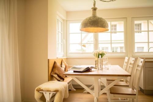 a dining room with a table and a pendant light at Grüne Hufe in Born