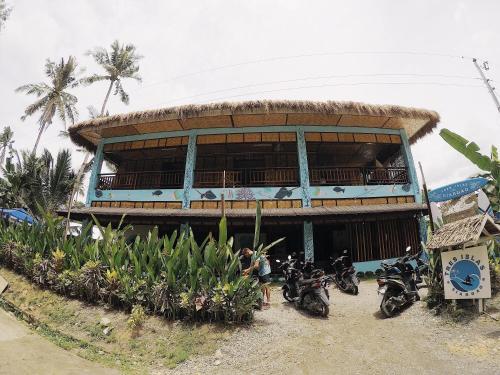 a building with motorcycles parked in front of it at Tres Islas Hostel in General Luna