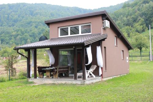 a small house with a table and chairs in a field at House Legacy in Bihać