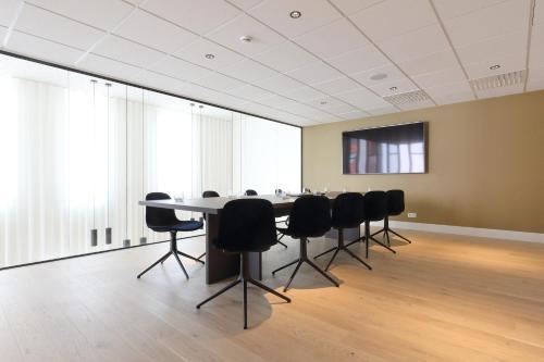 a conference room with a table and black chairs at Corsendonk Turnova in Turnhout