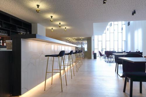 a row of stools in a bar in a restaurant at Corsendonk Turnova in Turnhout