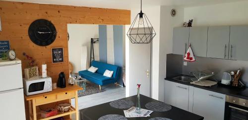 a kitchen with a blue couch in a room at Appartement 50m du Lac in Gérardmer