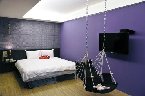 a bedroom with a bed with a swing at Tian Fang Ye Tan Hotel in Yilan City