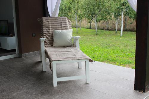 a chair with a pillow sitting on a porch at House Legacy in Bihać